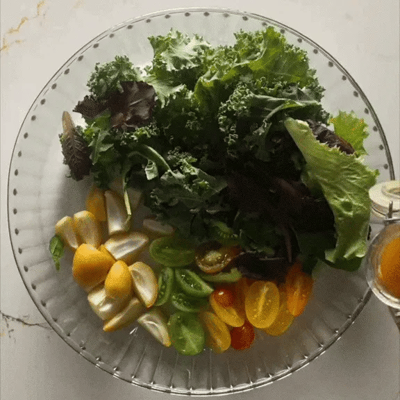 Puring vinaigrette over salad