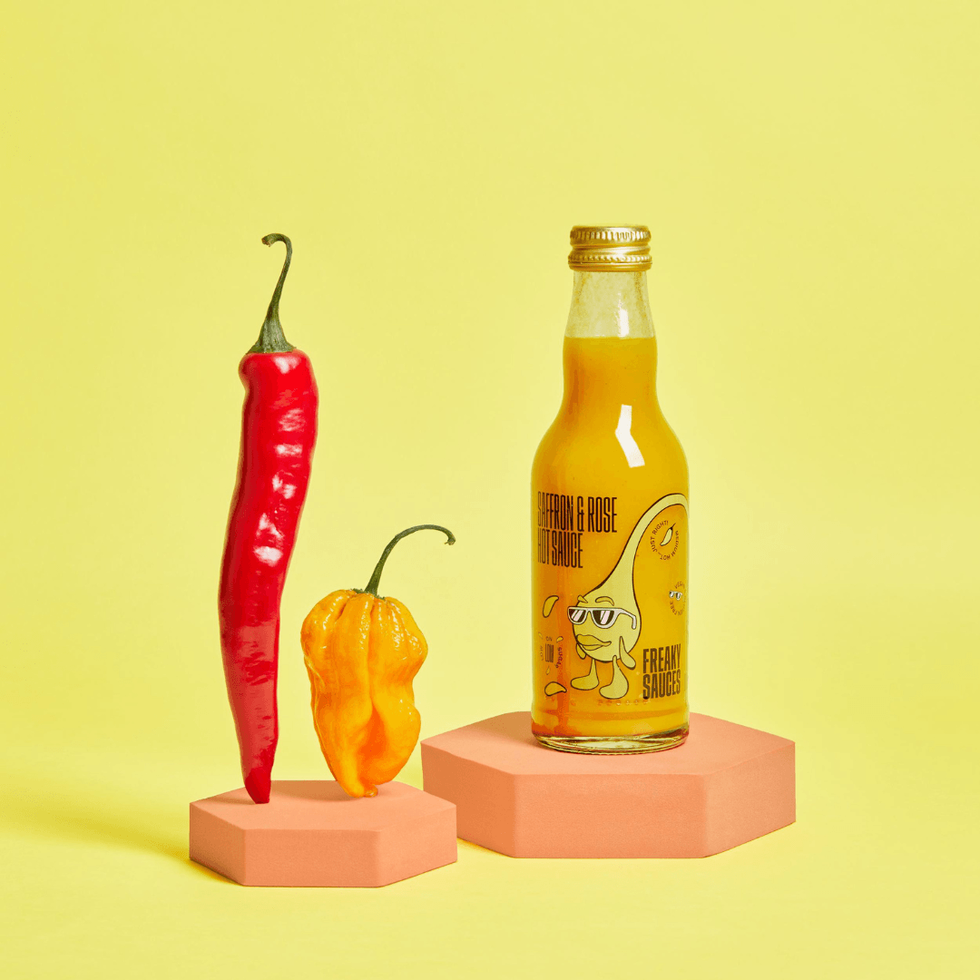 Saffron & Rose bottle next to two chilis